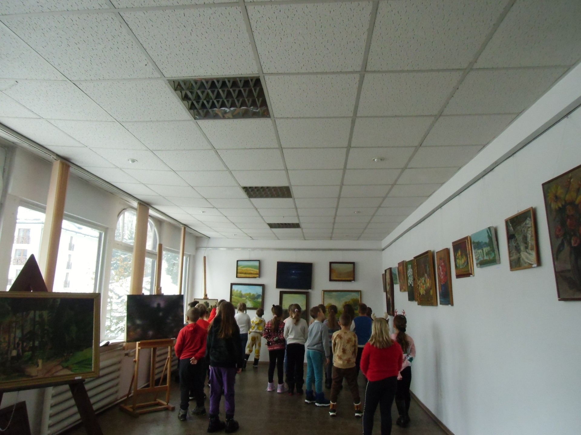Grupa dzieci ogląda prace w sali wystawowej